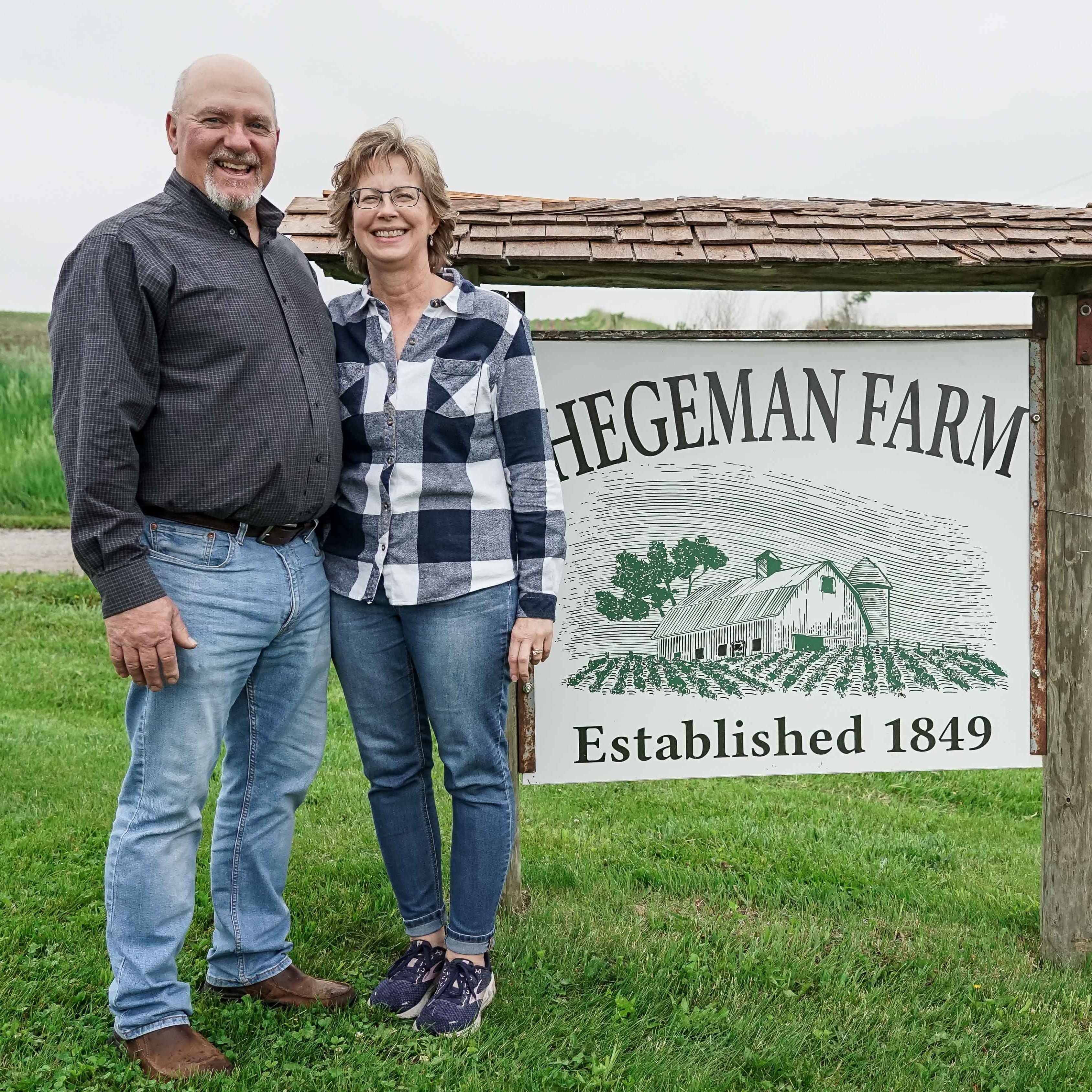 Fritz Hegeman and wife, Jennifer, next to the Hegeman farm sign.